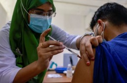 Women giving man a covid-19 vaccination. Credit: Abir Abdullah