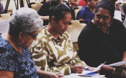  Three Fiji women seated looking at document. Credit: FWCC