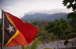 Flag of Timor-Leste in front of a cloud-covered mountain. Credit: Isabel Nolasco/Wikimedia Commons