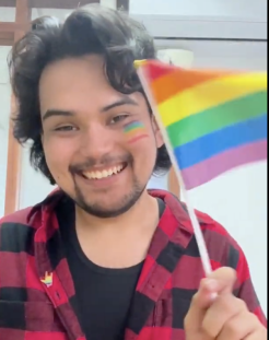 John from the Philippines waves a rainbow flag with a rainbow flag painted on his left cheek. Credit: FORUM-ASIA