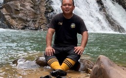 Gebril Atong in front of a waterfall. Credit: Gebril Atong