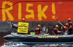 Greenpeace International activists painted the word “RISK!” on the starboard side of the Normand Energy, a vessel chartered by the Belgian company Global Sea Mineral Resources, April 21, 2021. Greenpeace’s Rainbow Warrior was in the Pacific Ocean to “bear witness,” the organization said, to equipment tests carried out by the company to “commercially extract minerals from the seabed in the future.” MARTEN VAN DIJL/GREENPEACE