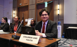 Photo of Hino Samuel Jose sitting behind a Children and Youth sign at 6th Asia Pacific Ministerial Forum on Environment. Credit: Hino Samuel Jose