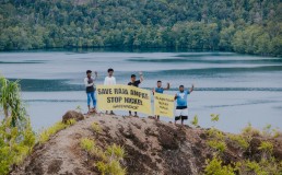 Several residents of Manyaifun Village, together with Greenpeace Indonesia activists, posed for a photo with a banner reading ‘Save Raja Ampat, Stop Nickel’ and ‘Selamatkan Hutan Papua’, with Manyaifun Village and the hills of Batang Pele Island in the background. Batang Pele Island is a tourism destination that also falls within a protected forest area and is part of the UNESCO Global Geopark. Currently, a nickel mining business permit is being proposed for the island by PT Mulia Reymond Perkasa, covering a concession area of 2,193 hectares, which includes both Manyaifun Village and Batang Pele Island. Credit: Alif R Nouddy Korua / Greenpeace