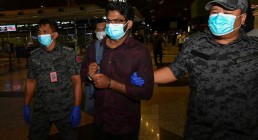 Bangladeshi Md Rayhan Kabir is escorted by Malaysian Immigration officers to the departure hall at Kuala Lumpur International Airport in Sepang, Malaysia, Aug. 21, 2020. S. Mahfuz/BenarNews