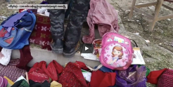 Still from the video showing a colleciton of children's backpacks on the ground with a legs and feet of a revolutionary soldier. Credit: PVTV International