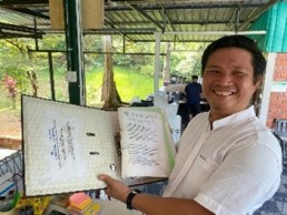 DTP alumnus Nasiri Sabiah with his DTP manual in Sabah Malaysia as part of Indigenous Peoples' Rights, Climate Change, Human Rights and Business training program. Credit: DTP