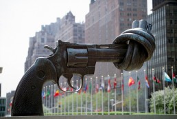 Knotted gun statue at UN with state flags in the background. Credit: UN Photo/x