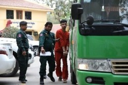 Photo of security officials and detainee